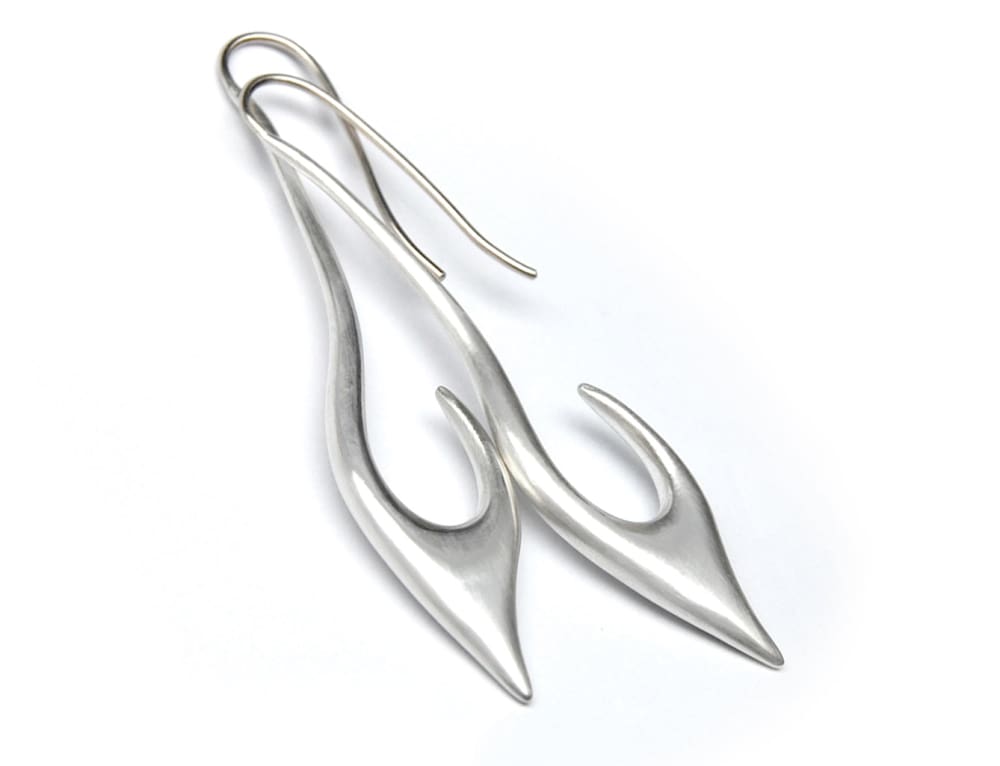 A pair of silver earrings with unique, curved shapes.