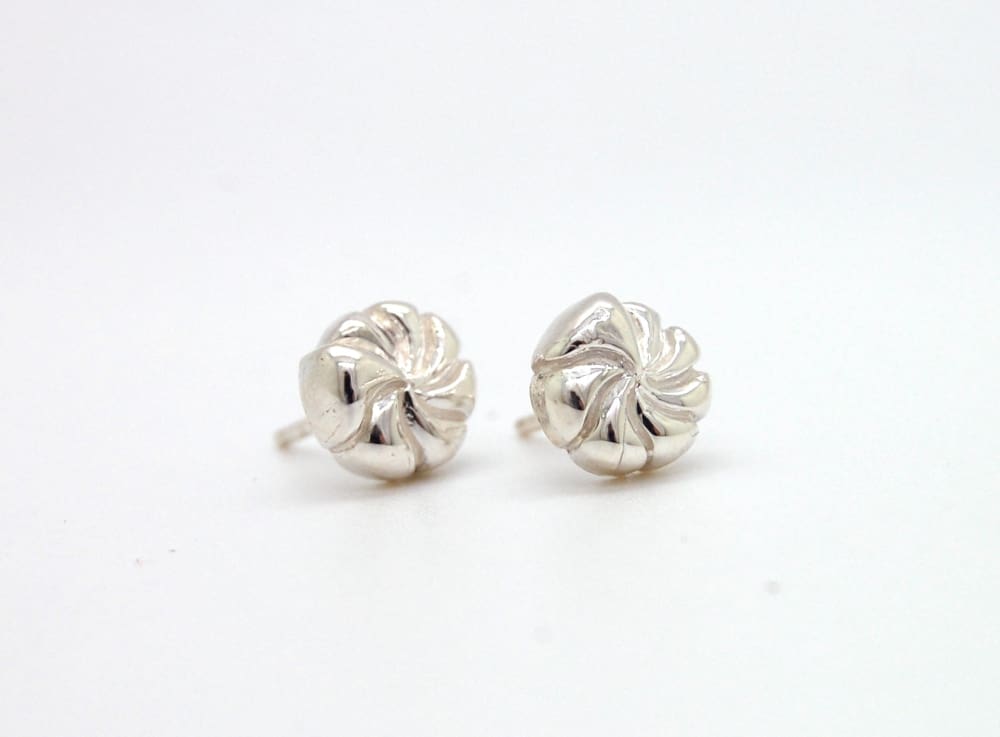 A pair of silver earrings with spiral designs on a white background.