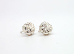 A pair of silver earrings with spiral designs on a white background.